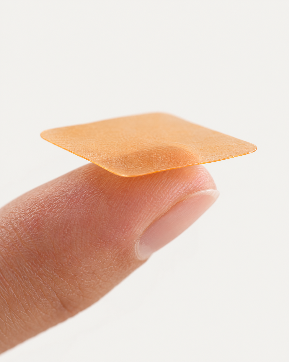 A thin orange strupps strip resting on a fingertip