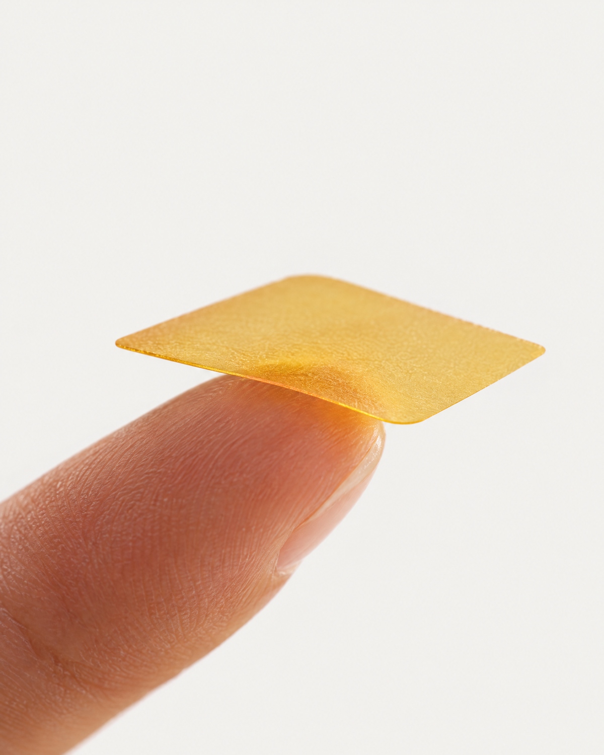 A thin amber strupps strip resting on a fingertip