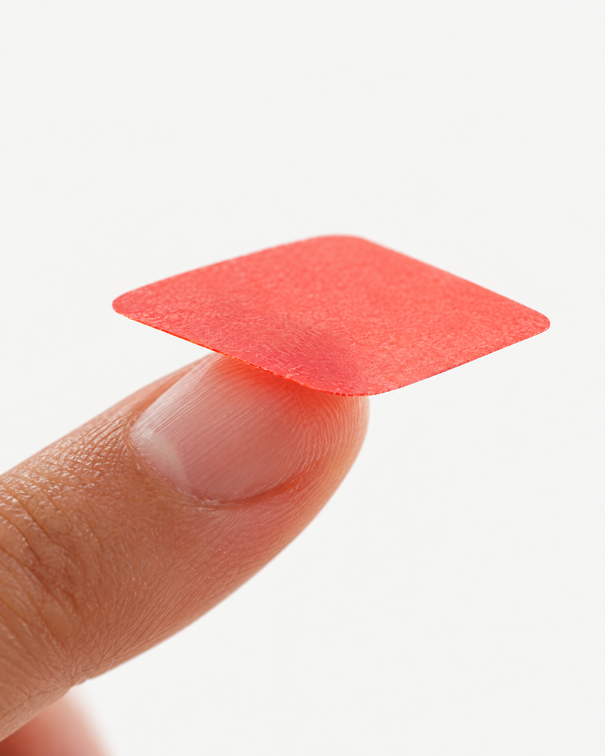 A thin red strupps Energy strip resting on a fingertip